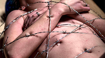 Barbed wire scratches the skin of the masochist. Extreme bondage for the bravest